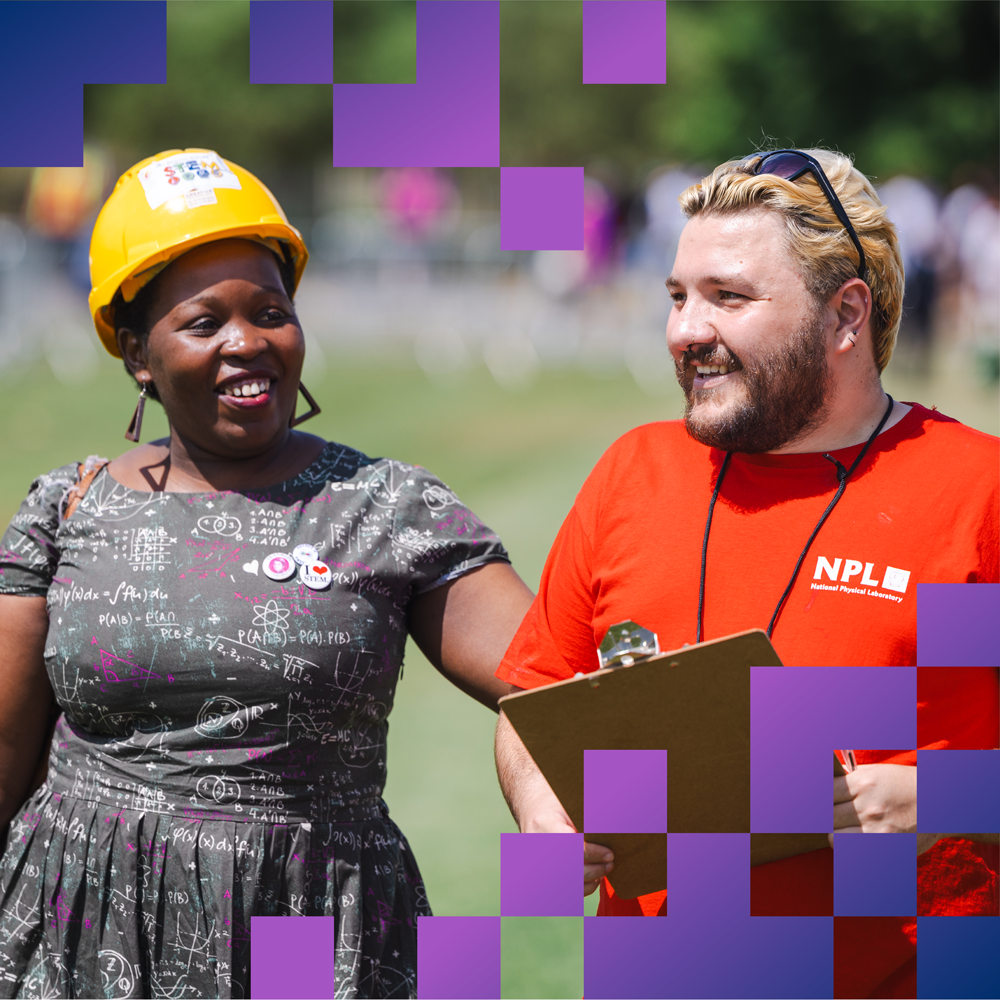 Person with helmet on and another smiling apprentice wearing orange NPL shirt with clipboard